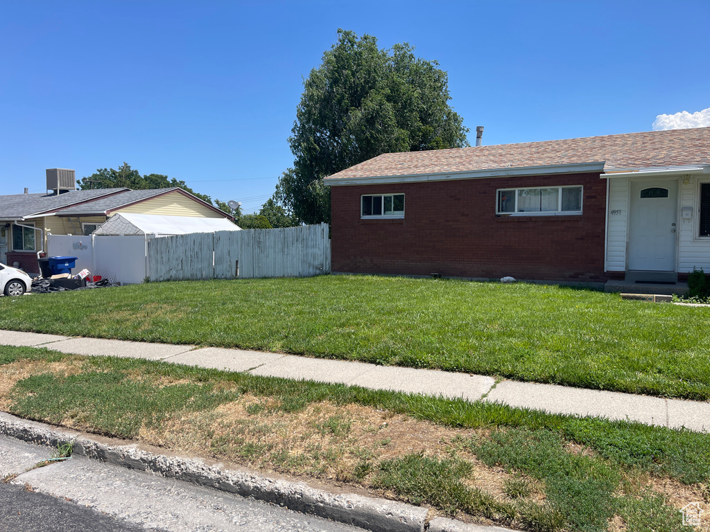 View of side of home featuring a yard