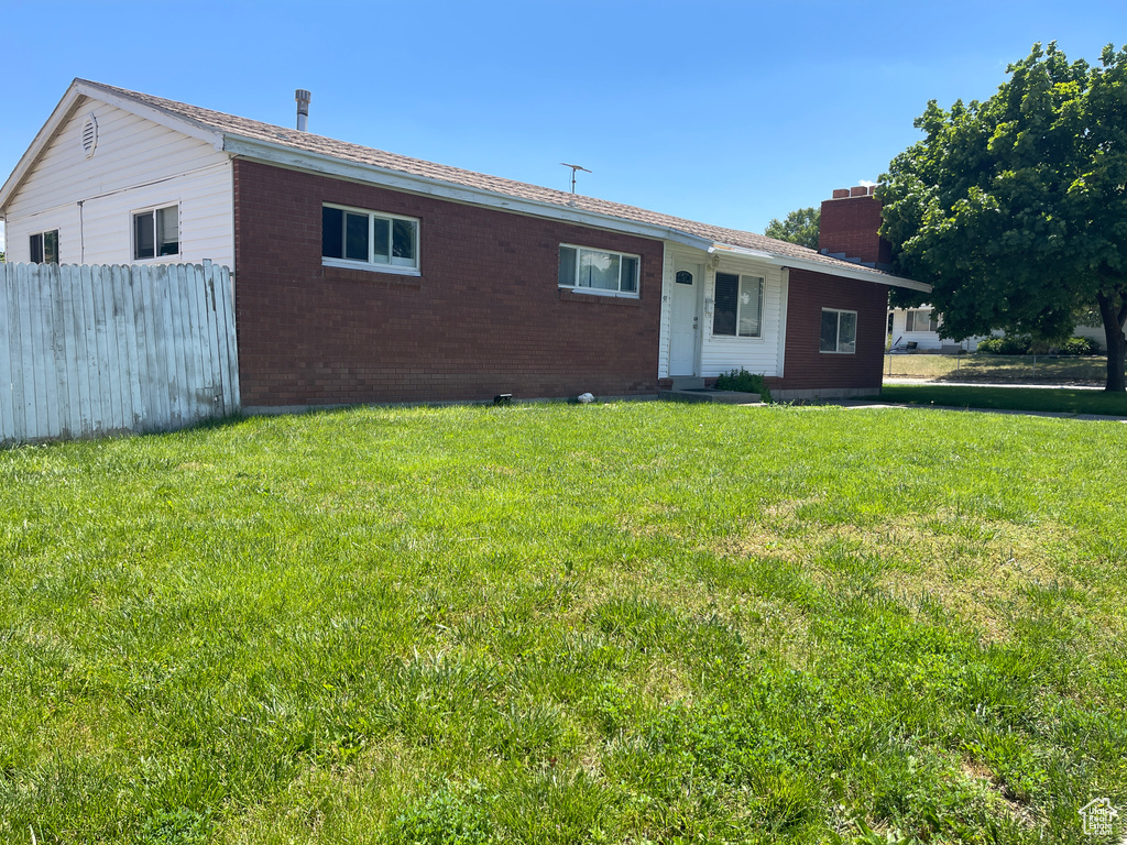 Back of house with a yard