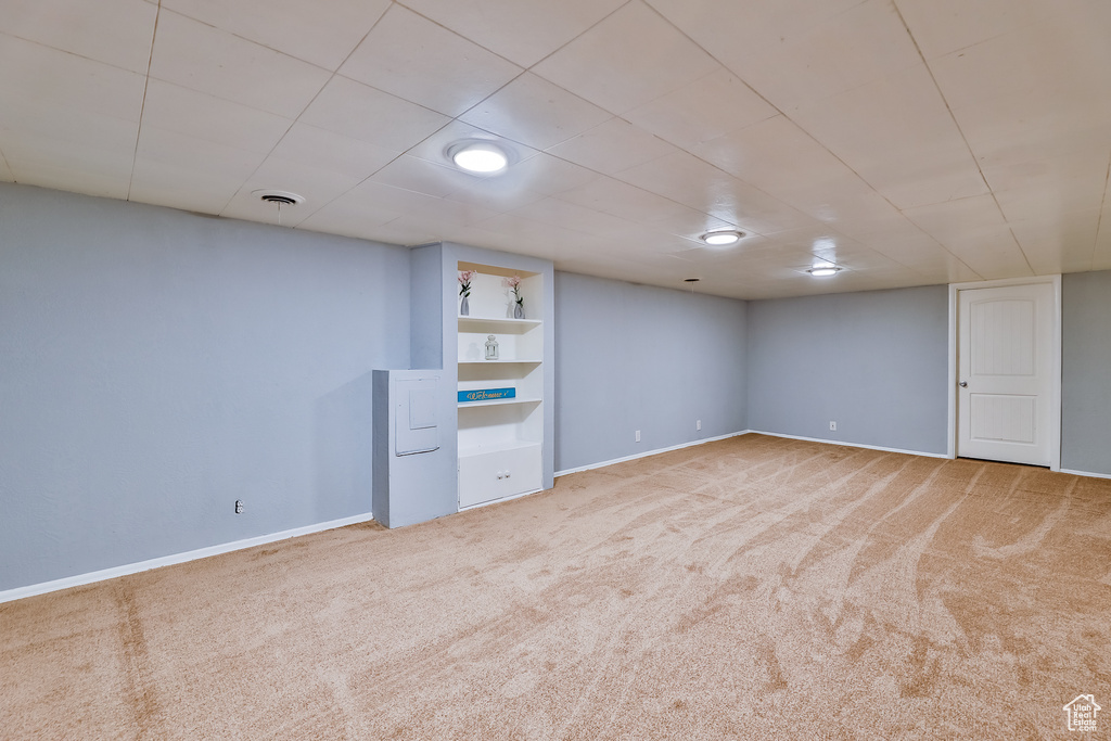 Basement featuring built in features and carpet flooring