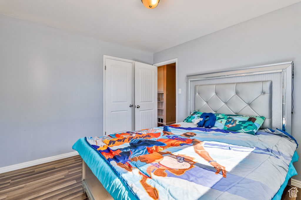 Bedroom featuring dark wood-type flooring and a closet