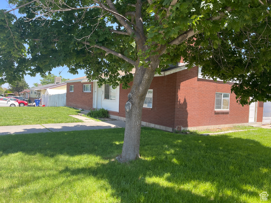 View of property exterior featuring a lawn