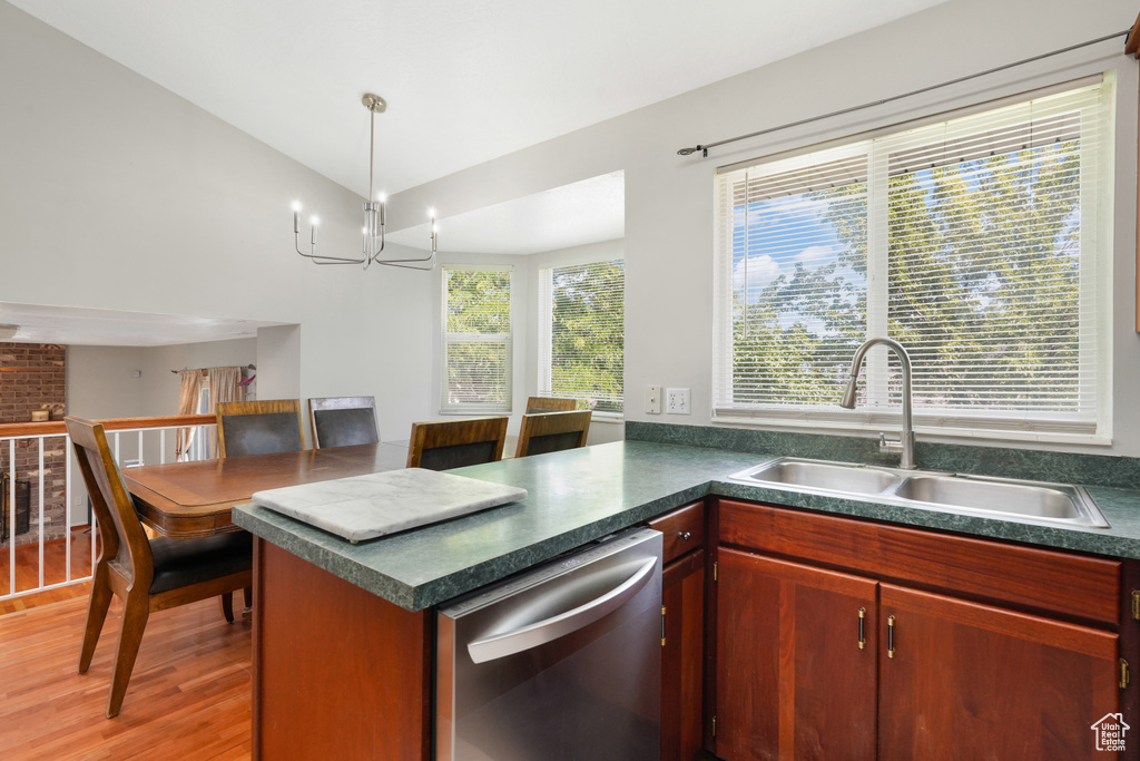 Kitchen with light hardwood / wood-style floors, an inviting chandelier, decorative light fixtures, sink, and dishwasher