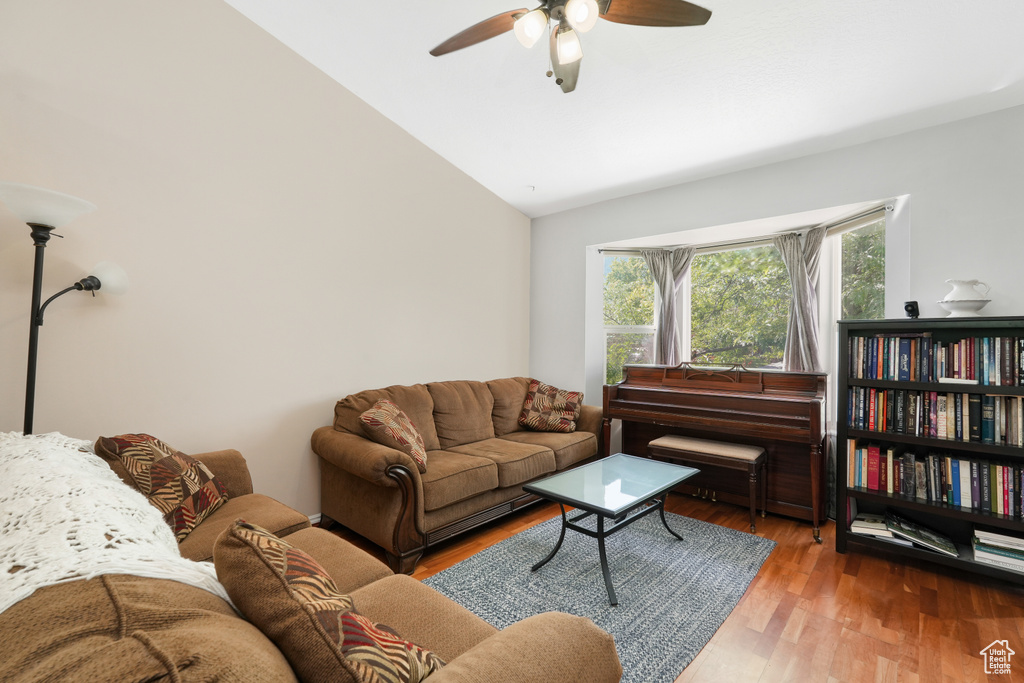 Living room with ceiling fan, vaulted ceiling, and hardwood / wood-style floors