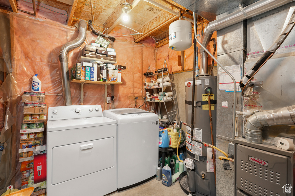 Laundry area with heating utilities, strapped water heater, and washing machine and clothes dryer