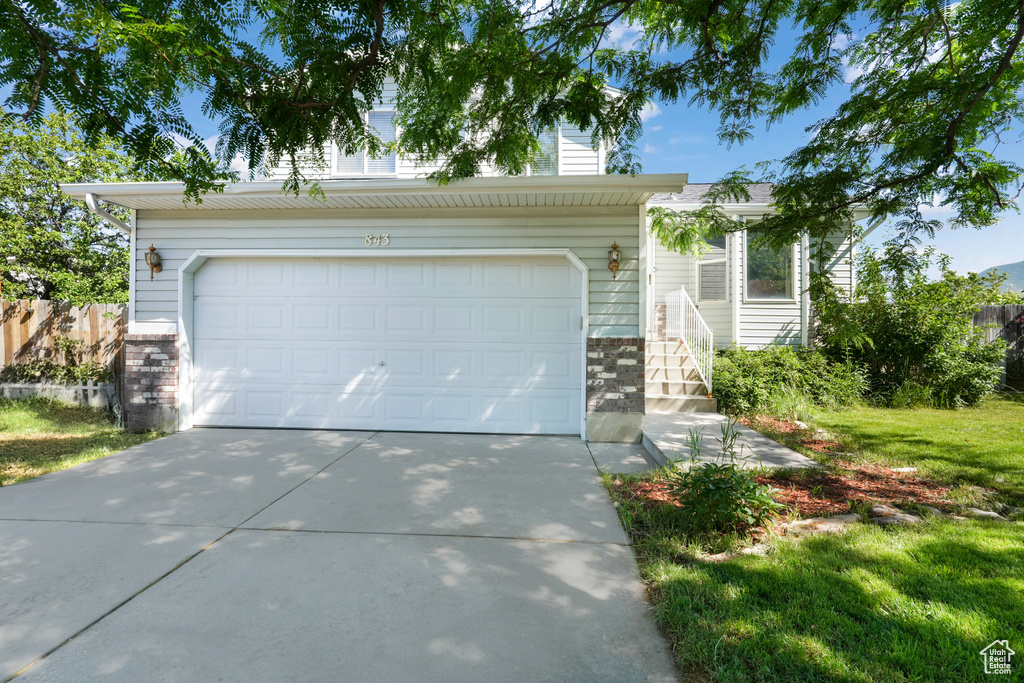 View of front of home featuring a front lawn and a garage