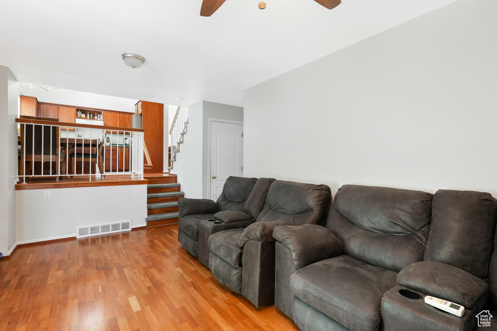 Living room with ceiling fan and hardwood / wood-style floors