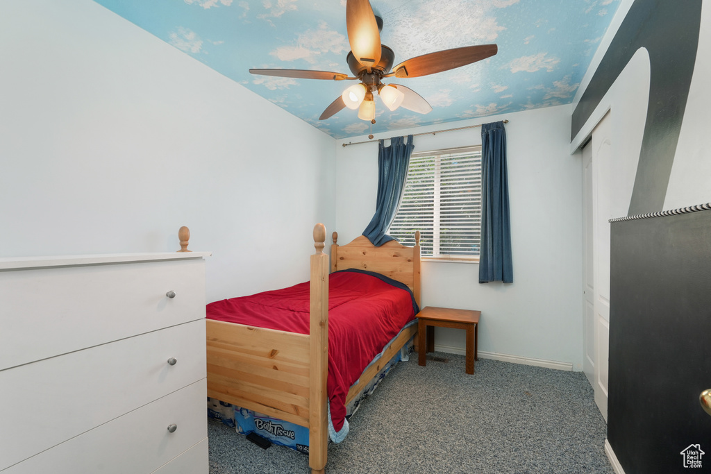 Carpeted bedroom featuring ceiling fan