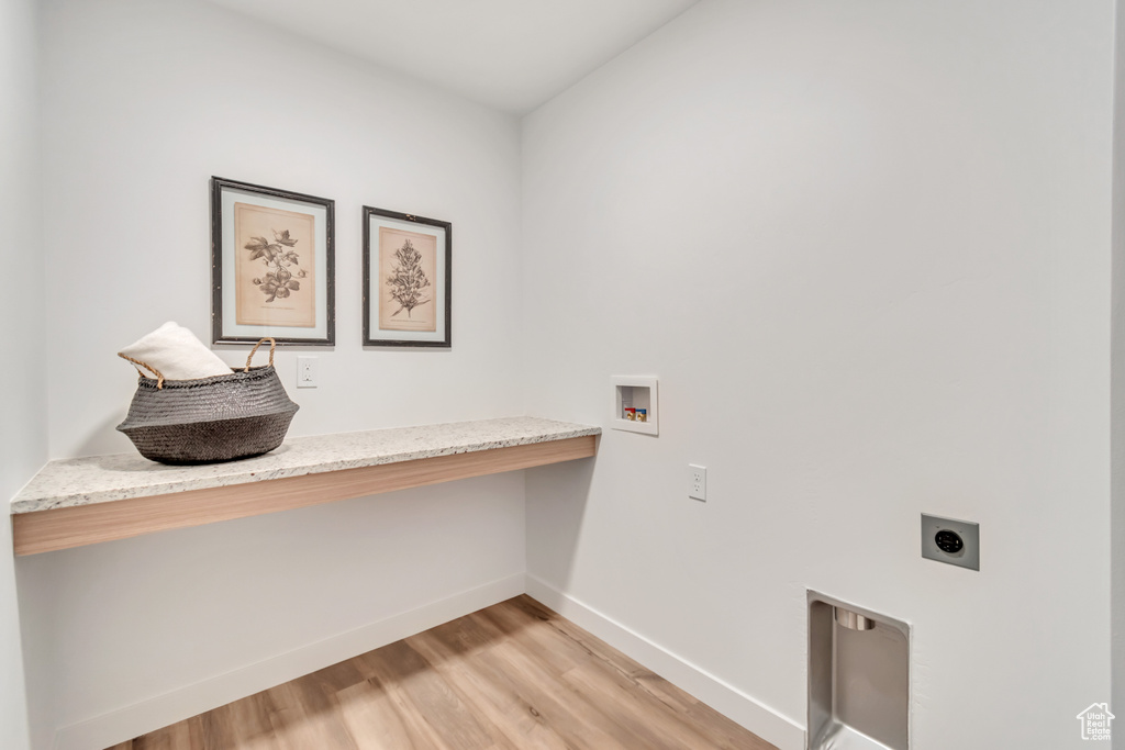 Clothes washing area with light hardwood / wood-style floors, hookup for an electric dryer, and washer hookup