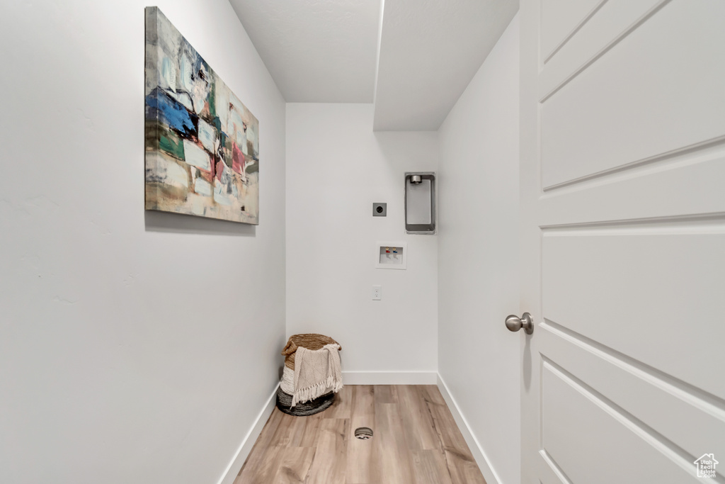 Washroom featuring electric dryer hookup, light wood-type flooring, and hookup for a washing machine