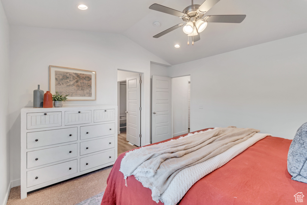 Carpeted bedroom with ceiling fan and vaulted ceiling