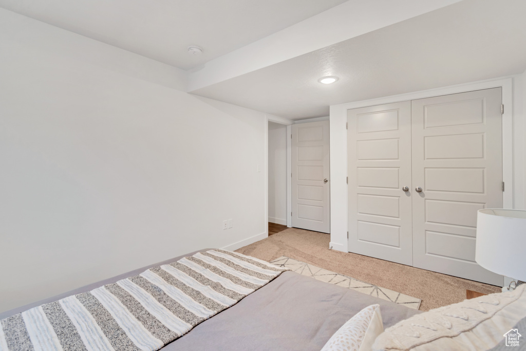 Unfurnished bedroom featuring light colored carpet and a closet