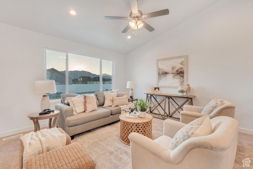 Carpeted living room featuring high vaulted ceiling and ceiling fan