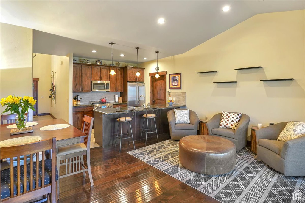 Living room with dark wood-type flooring and vaulted ceiling