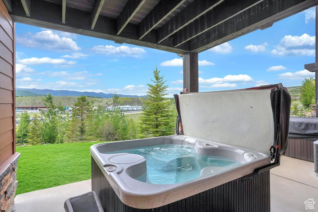 View of patio featuring a mountain view and a hot tub
