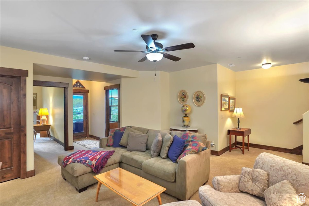 Carpeted living room with ceiling fan