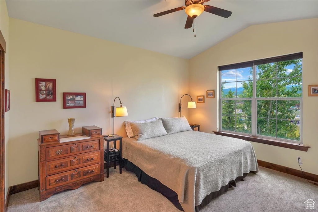 Carpeted bedroom featuring lofted ceiling and ceiling fan