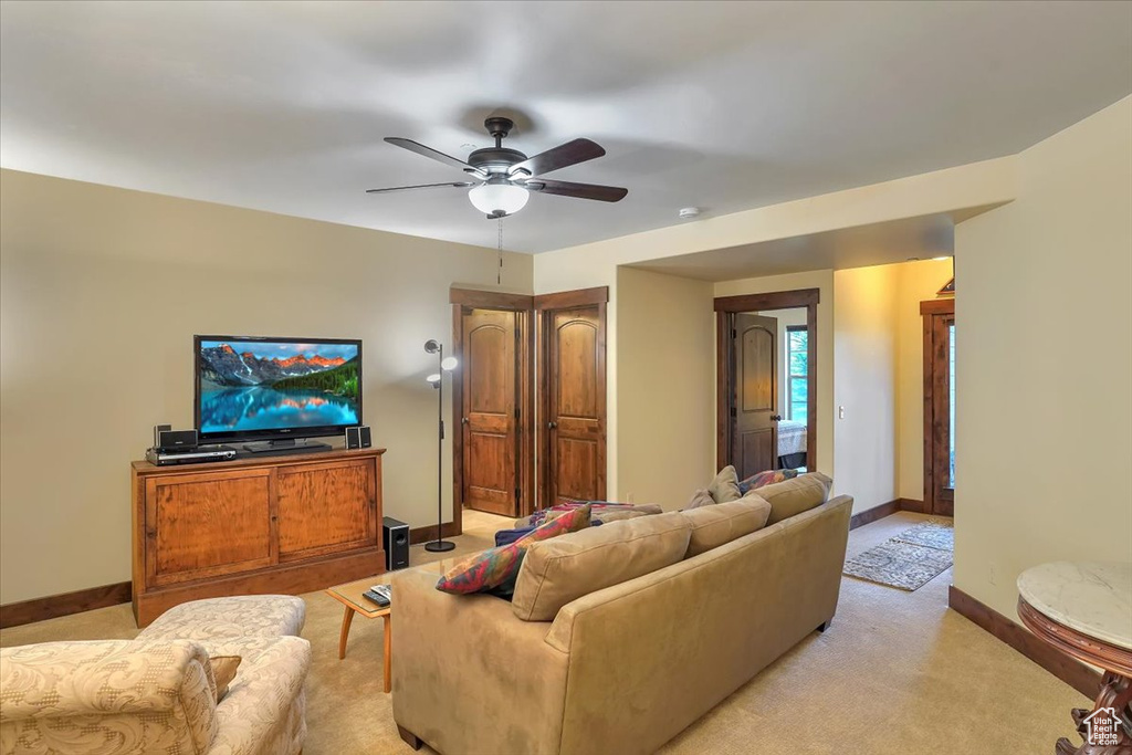 Carpeted living room featuring ceiling fan