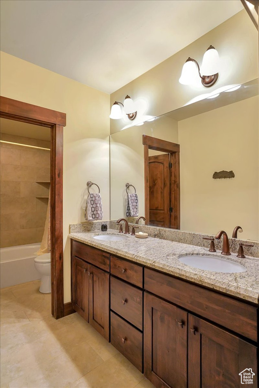 Full bathroom featuring dual vanity, tiled shower / bath, tile flooring, and toilet
