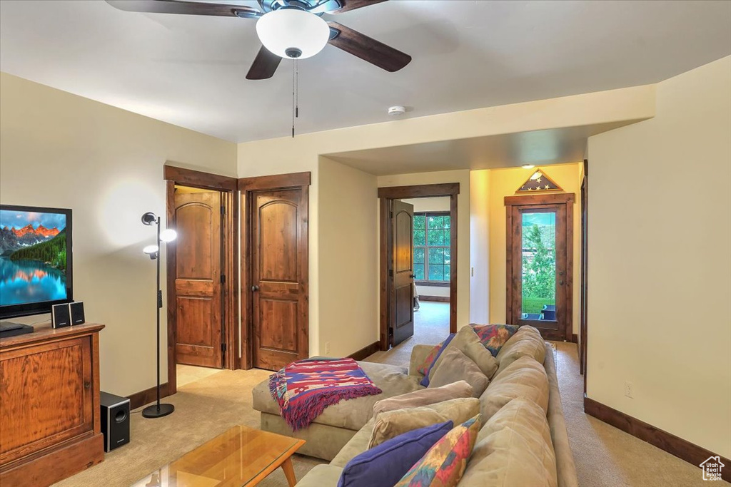 Living room featuring ceiling fan and light carpet