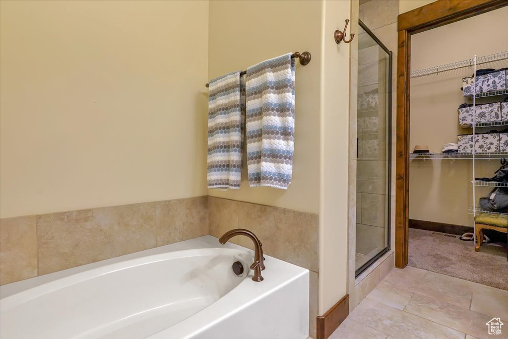 Bathroom featuring tile flooring and plus walk in shower