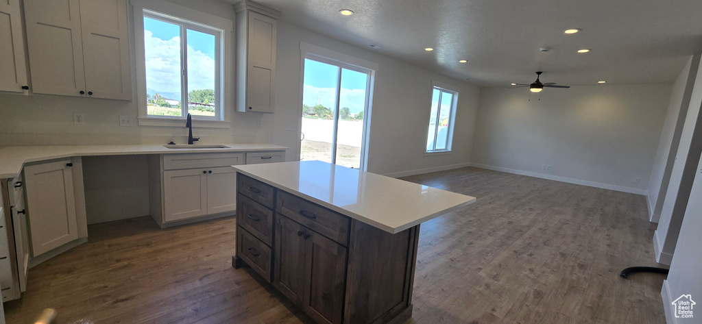 Kitchen with a center island, hardwood / wood-style flooring, sink, and ceiling fan