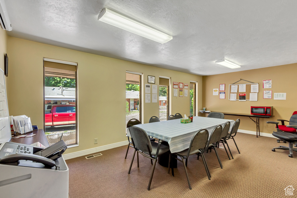 Dining area featuring carpet floors and a textured ceiling