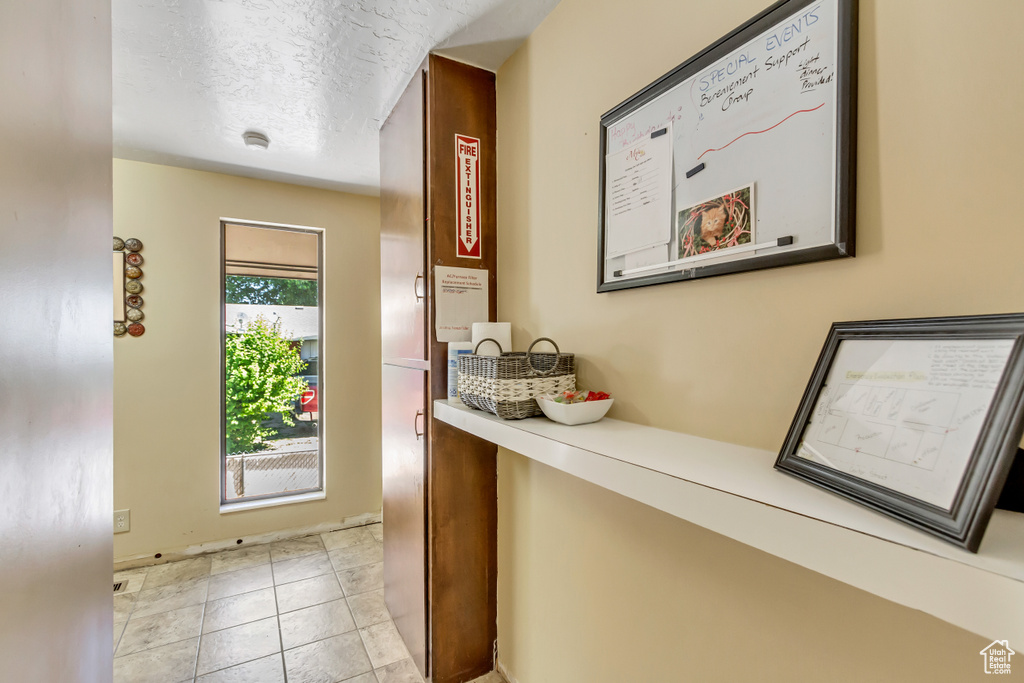 Hallway with plenty of natural light and light tile floors