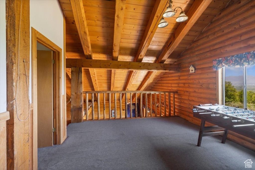 Interior space featuring carpet, vaulted ceiling with beams, log walls, and wood ceiling