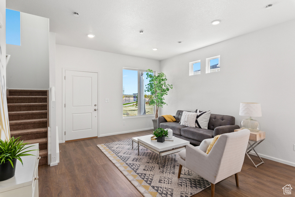 Living room with dark hardwood / wood-style floors and a healthy amount of sunlight