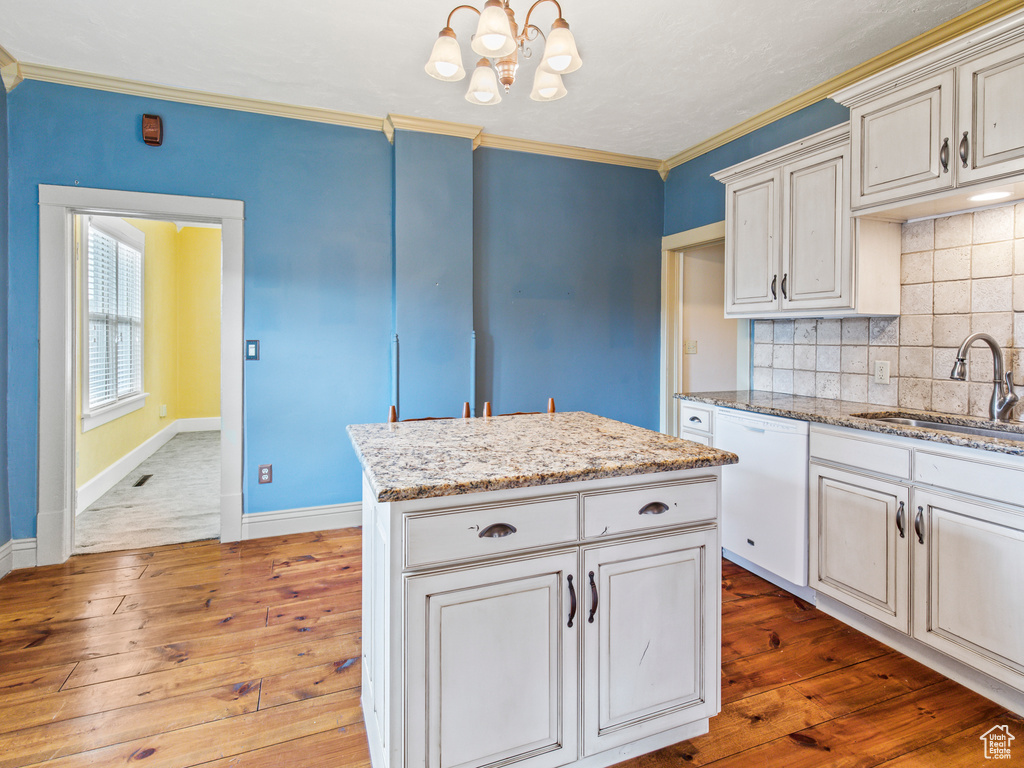 Kitchen with a center island, hardwood / wood-style floors, sink, tasteful backsplash, and dishwasher