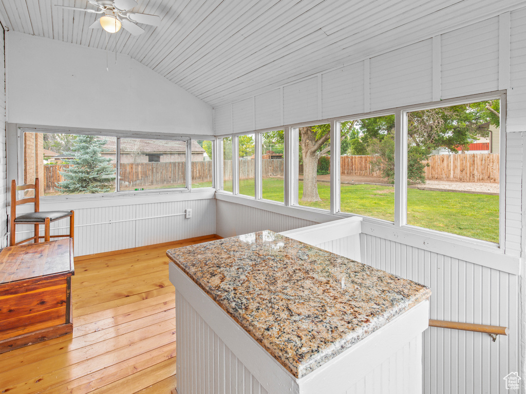 Sunroom with a wealth of natural light, ceiling fan, and lofted ceiling