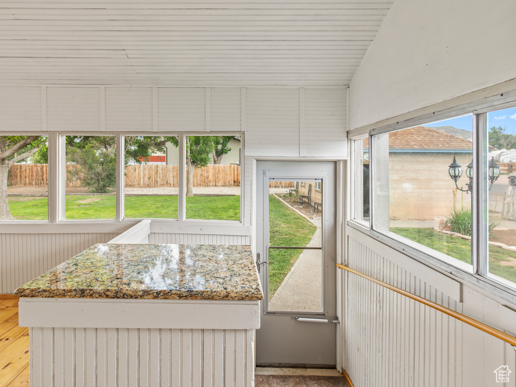 Unfurnished sunroom with a wealth of natural light and vaulted ceiling