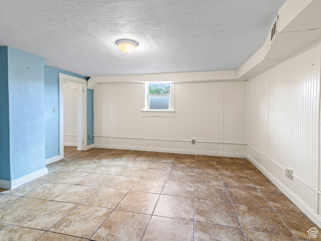 Spare room featuring tile flooring and a textured ceiling