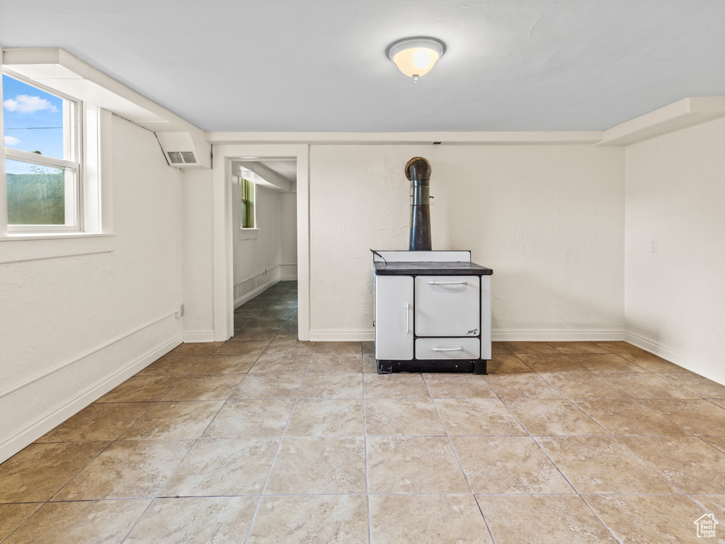 Basement with tile flooring and a wood stove