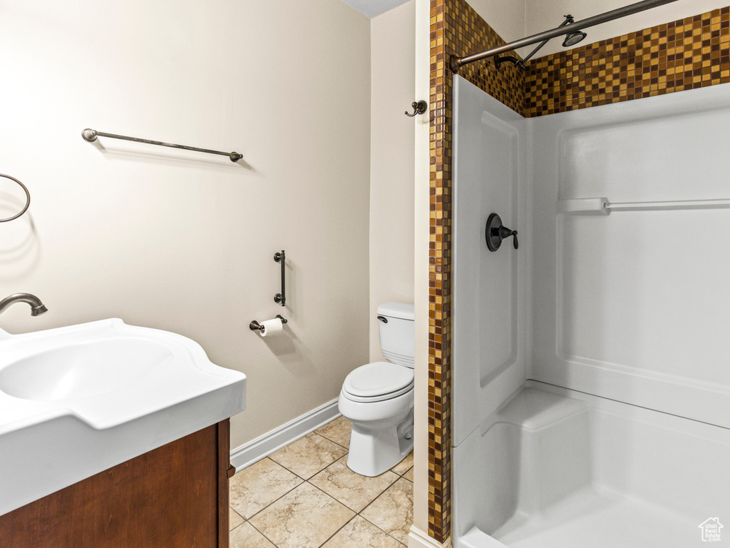 Bathroom featuring tile floors, a shower, toilet, and vanity