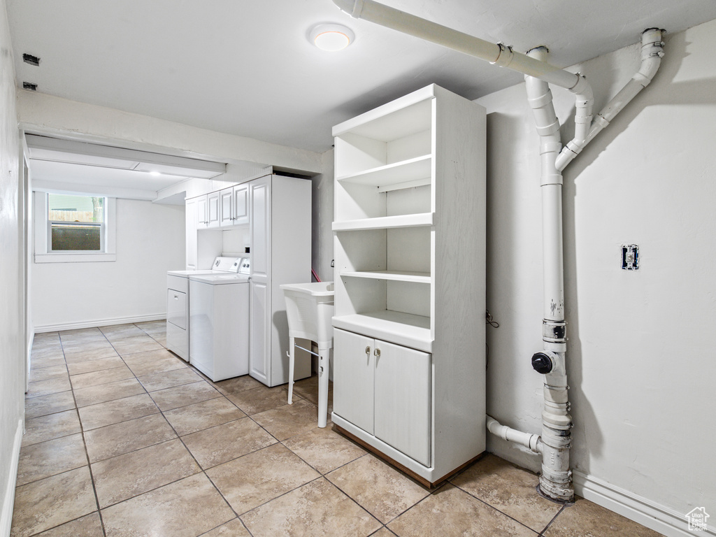 Laundry room featuring washer and dryer and light tile floors