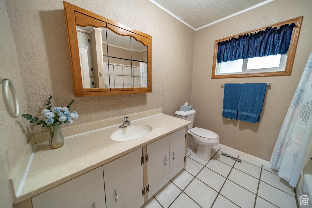 Bathroom with tile flooring, toilet, ornamental molding, and oversized vanity