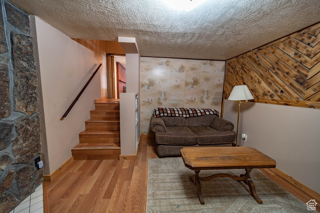 Living room featuring a fireplace, hardwood / wood-style floors, and a textured ceiling