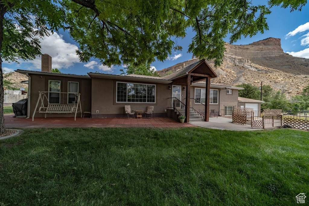 Back of house featuring a lawn and a patio area