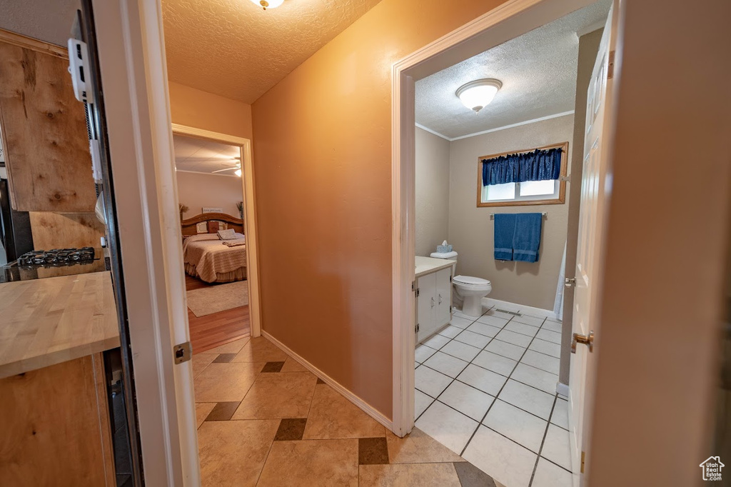 Bathroom featuring tile floors, a textured ceiling, toilet, and vanity