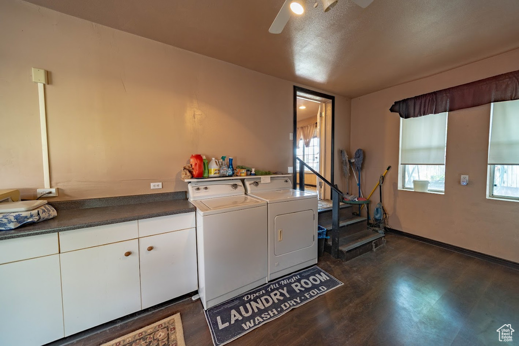 Washroom featuring ceiling fan, washer and dryer, dark wood-type flooring, a textured ceiling, and cabinets