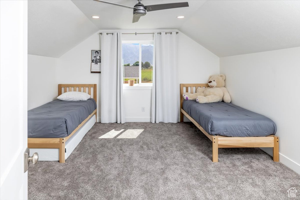 Unfurnished bedroom featuring vaulted ceiling, carpet, and ceiling fan