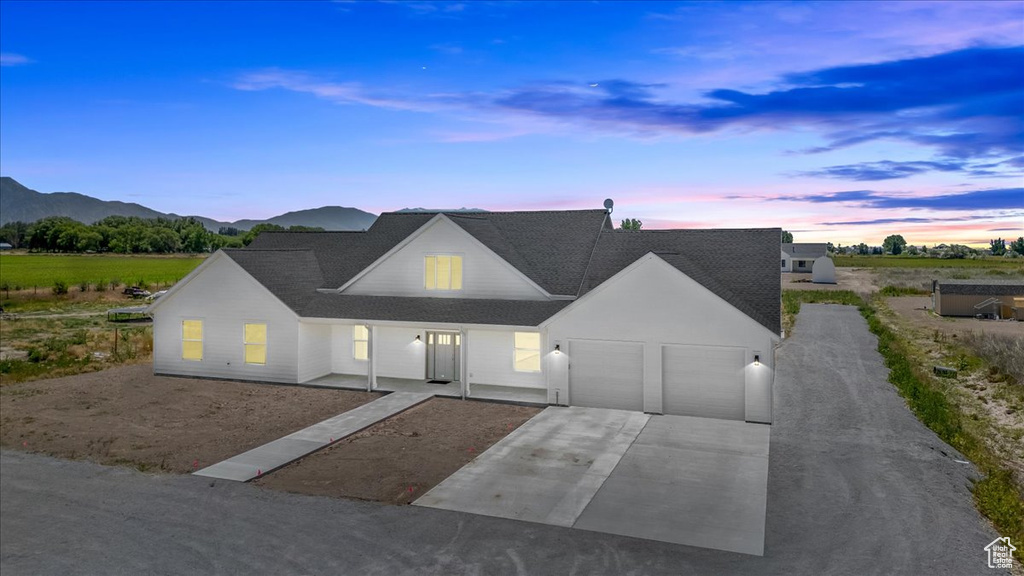 View of front of property with a garage and a mountain view