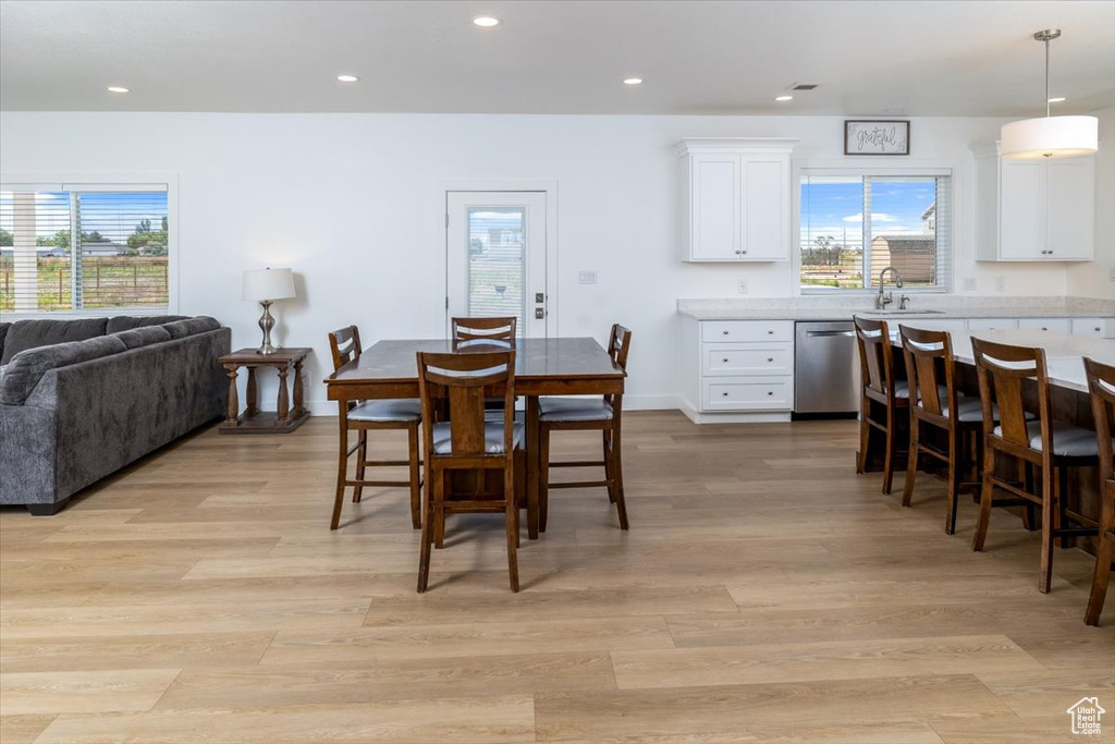 Dining room with a healthy amount of sunlight, sink, and light hardwood / wood-style flooring