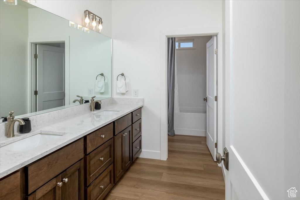 Bathroom with hardwood / wood-style flooring and dual vanity