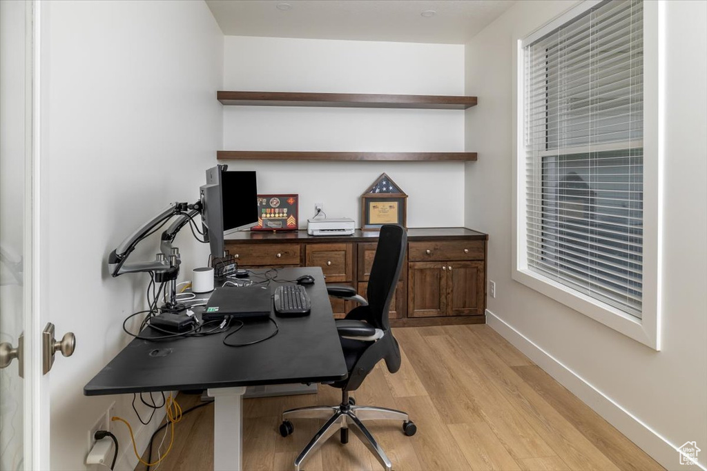 Office space with light hardwood / wood-style flooring