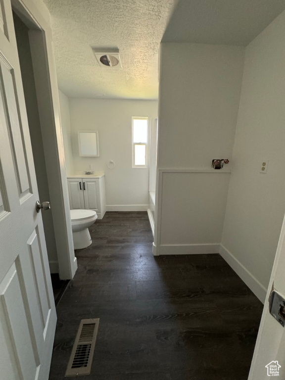 Bathroom with hardwood / wood-style flooring, toilet, a textured ceiling, and vanity