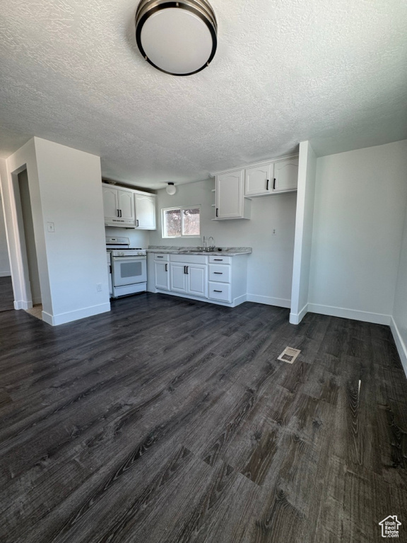 Kitchen with white range, dark hardwood / wood-style flooring, a textured ceiling, sink, and white cabinetry