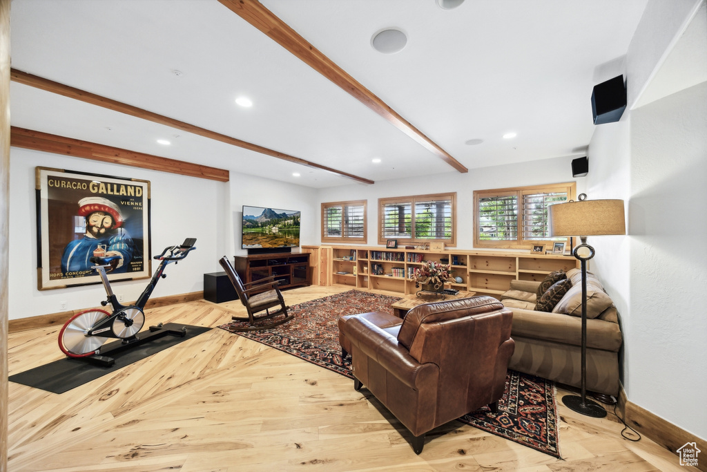 Living room with beamed ceiling and light hardwood / wood-style flooring