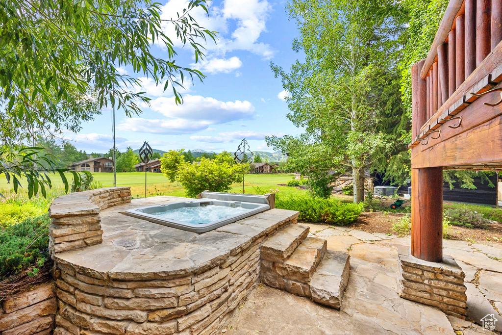 View of patio with an outdoor hot tub